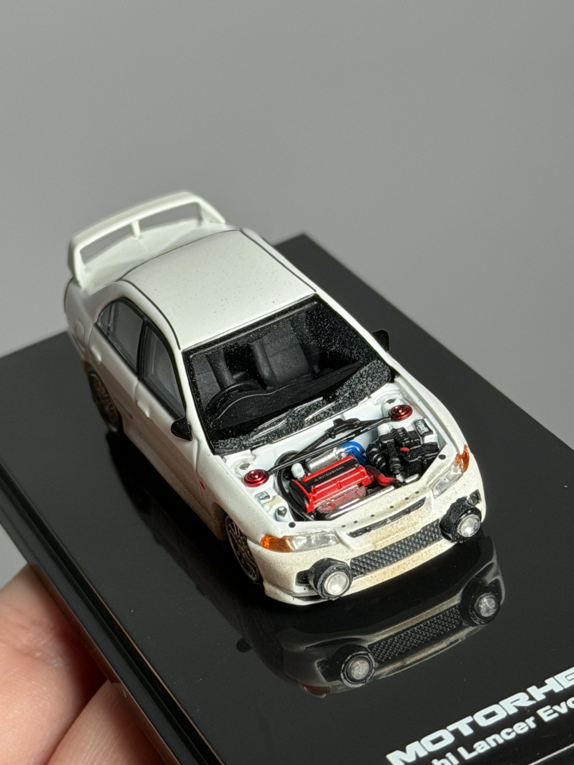 MOTORHELIX 1:64 Mitsubishi Lancer Evolution lV Versión embarrada con capó removible - Imagen 6