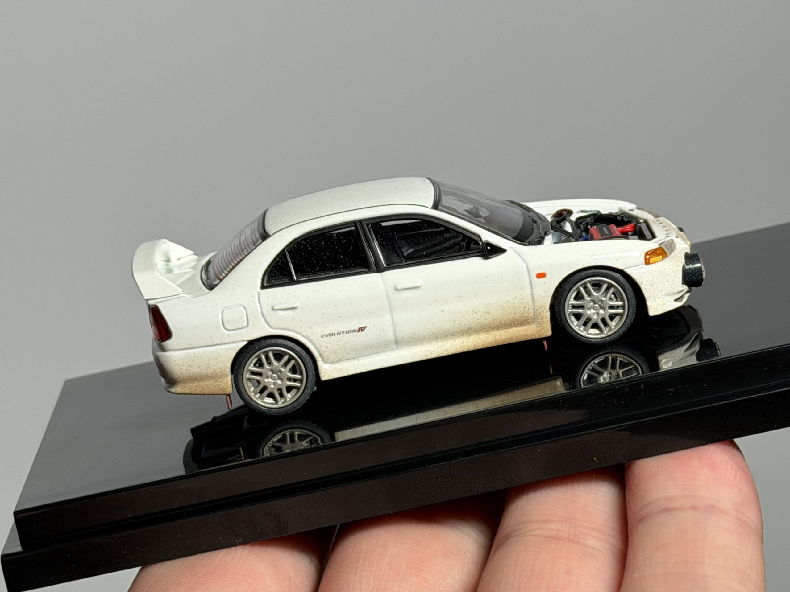 MOTORHELIX 1:64 Mitsubishi Lancer Evolution lV Versión embarrada con capó removible - Imagen 7