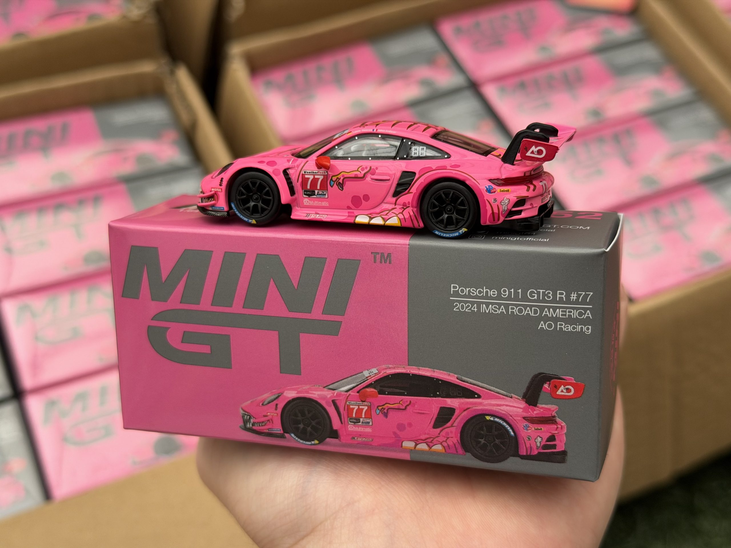 Mini GT 1:64 Porsche 911 GT3 R #77 AO Racing 2024 IMSA ROAD AMERICA Roxy en empaque de CAJA